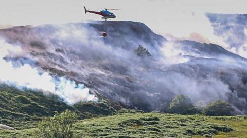 Helicopter over moorland fire