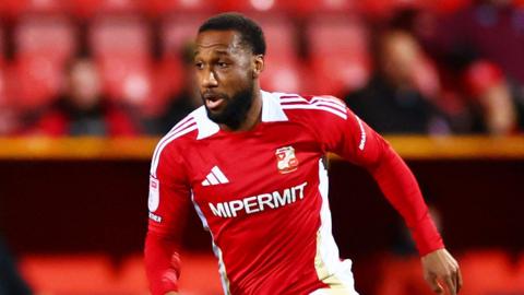 Junior Hoilett runs with the ball while playing for Swindon Town