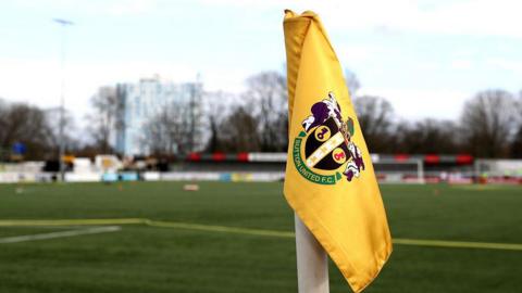 Sutton United's stadium with a close-up of their yellow corner flag