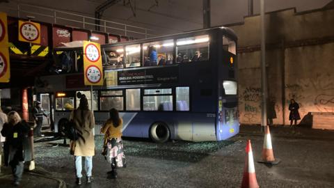 A first bus wedged under the railway bridge at Cook Street/Commerce Street in Glasgow city centre