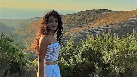 Maria Shaya, 31, stands in front of a hill in her hometown of Alma al-Shaab