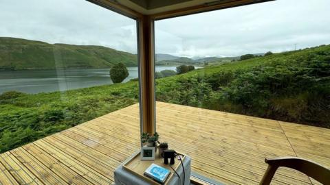 The view of Loch Harport from inside a compact, tin clad home on the Isle of Skye