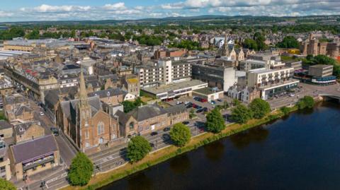 An aerial view of Inverness showing homes, churches and office blocks on Inverness' Riverside. Inverness Castle is in the far right of the image.