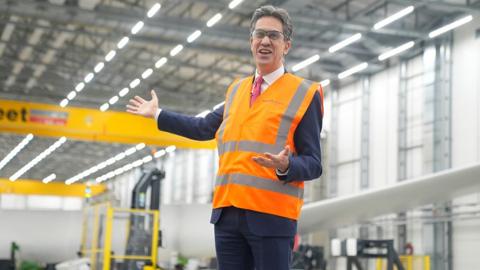 Energy Secretary Ed Miliband in a high visibility vest and protective glasses stands in the Siemens Gamesa wind turbine factory in Hull