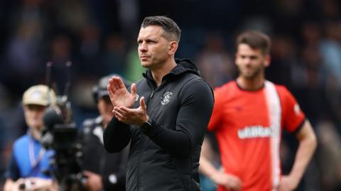 Manager Matt Bloomfield applauds away fans following Luton's West Brom loss