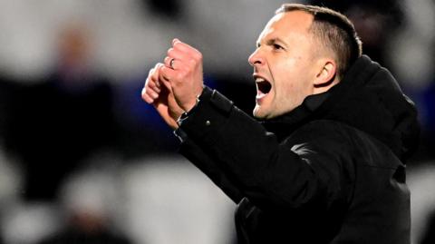 Birmingham City boss Chris Davies punches the air with both fists in celebration