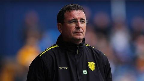 Burton Albion head coach Gary Bowyer wearing a black jacket with the Burton badge on in yellow