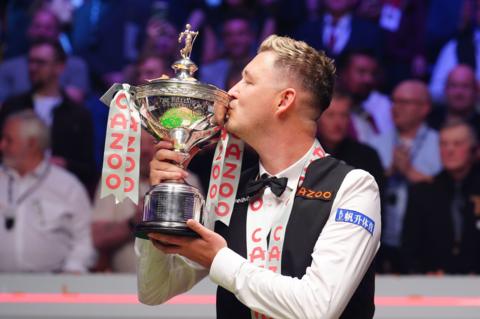 Kyren Wilson kisses the World Championship trophy