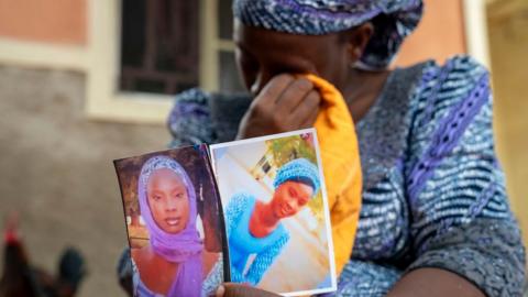 Woman holding photos while crying