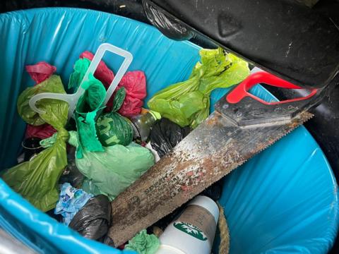 A saw put in a rubbish bin 