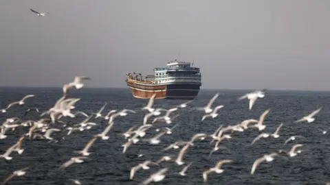 Birds fly near the boat in the Strait of Hormuz amid the U.S.-Israeli conflict with Iran, as seen from Musandam, Oman, March 2, 2026.