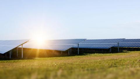 A generic picture of solar panels in sunshine in front of a clear blue sky.