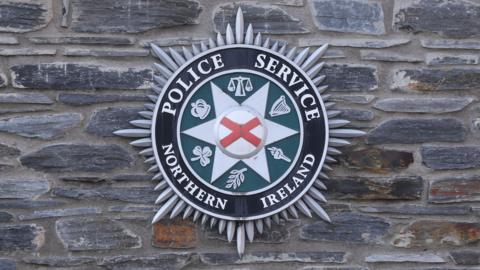 Logo of Police Service Northern Ireland on a brick wall