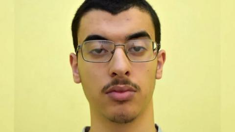A headshot of Hashem Abedi wearing glasses facing the camera against a yellow background.