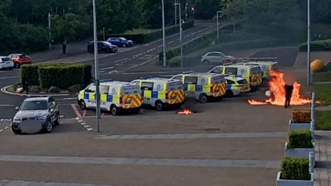 Man throws molotov cocktails at a police officer and police vans