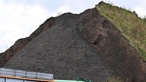 The mound of material on Simonswood Industrial Estate