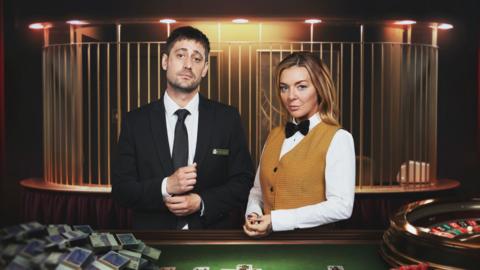 Michael Socha as Matty and Sheridan Smith as Leanne in The Cage. Both are pictured inside a casino, dressed as casino employees.