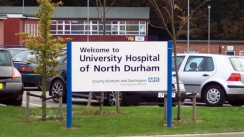 A sign reading University Hospital of North Durham, outside the hospital.