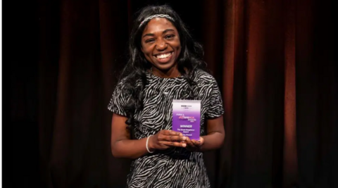 Make a Difference award winner holding her award in her hands 