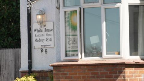 A close up of a sign on a residential building which reads "The White House Residential Home, Medway" 
