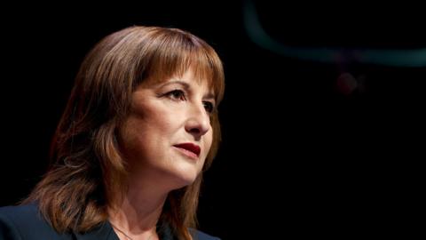Close up with black background of Rachel Reeves with a serious and concerned facial expression  looks out to the right of the photo.