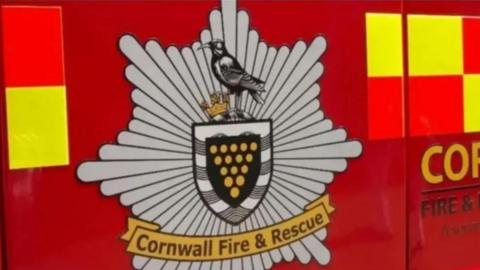A Cornwall Fire and Rescue Service logo on the side of a fire engine.