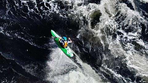 A kayaker navigating powerful white-water rapids.