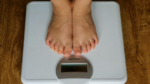 A young child's feet stood on weighing scales 