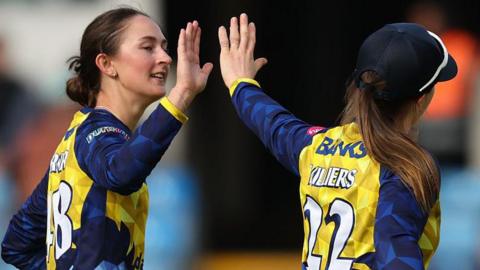 Heather Graham hets a high five from Durham skipper Mady Villers.