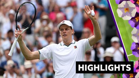 Jannik Sinner holds his arms up in the air