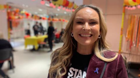 A woman smiles at the camera