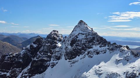 Snow covered, jaggy, mountain peak in the sunshine.