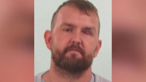 Image of Steven. He has a blonde/ginger beard and large ears. He is wearing a grey jumper.