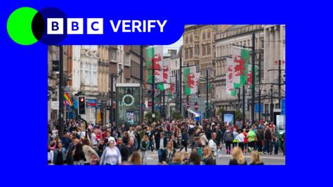 Welsh flags and people in the centre of Cardiff's St Mary Street