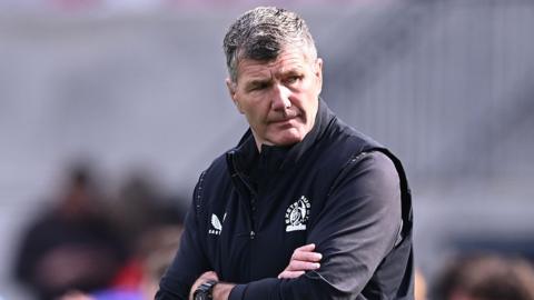 Rob Baxter stands with his arms folded