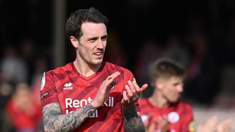 Toby Mullarkey applauds the Crawley Town fans during the 2024-25 season
