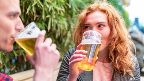 A man and a woman drinking alcohol-free beer in a beer garden