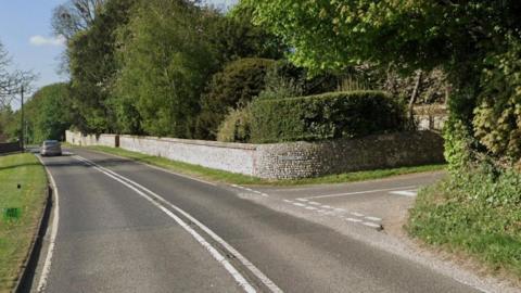 A Google Maps image showing a t-junction on an A road in Sussex with a flint stone wall encasing a property on the corner of the junction