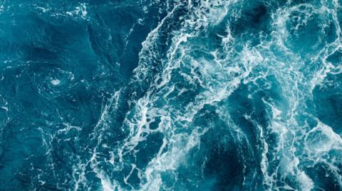 blue ocean with froth from waves.