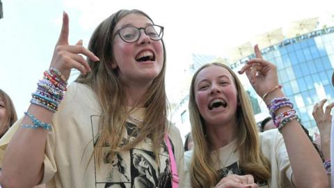 Two young Taylor Swift fans singing on the streets of Vienna