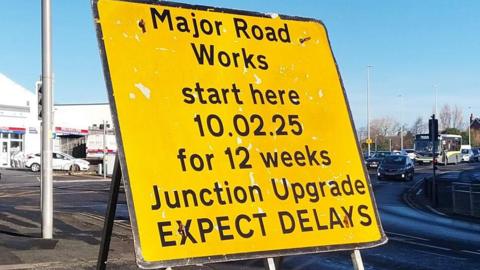 A large yellow sign announcing roadworks in black text at the junction in Blackpool