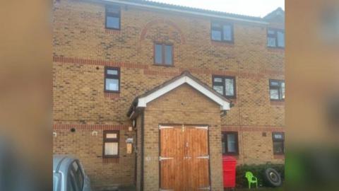 Yellow and red brick building of three storey council flats in Slough.