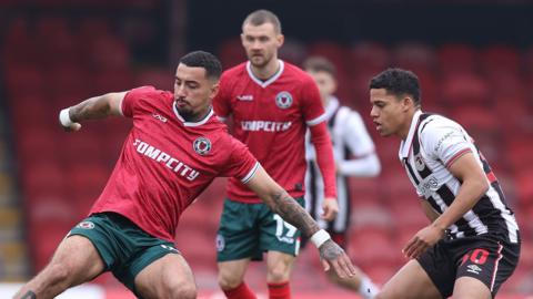 Courtney Baker-Richardson (L) of Newport and Evan Khouri of Grimsby Town compete