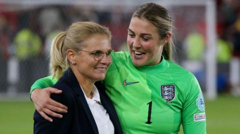 Mary Earps puts her arm around the shoulder of England head coach Sarina Wiegman