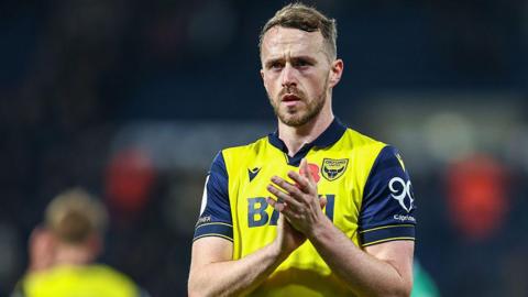 Oxford United defender Sam Long applauds the fans after a game