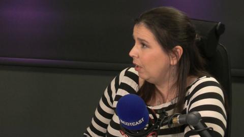 Falkirk councillor Laura Murtagh sitting in the Scotcast studio, she has shoulder length dark hair and a black and white striped top.