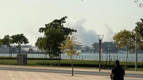 A photograph of a man looking at the smoke in the sky 