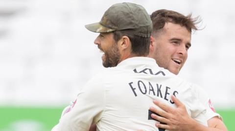 Surrey team-mates Ben Foakes and Tom Lawes celebrate a wicket