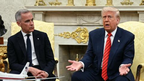 Mark Carney sitting next to Donald Trump at the White House in May