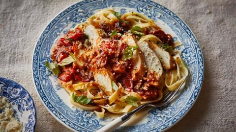 Chicken and tomato pasta on a blue plate